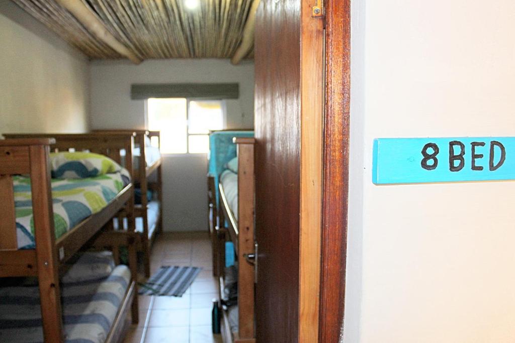 a room with bunk beds and a sign that says bed at The Wild Farm Backpackers in Wilderness