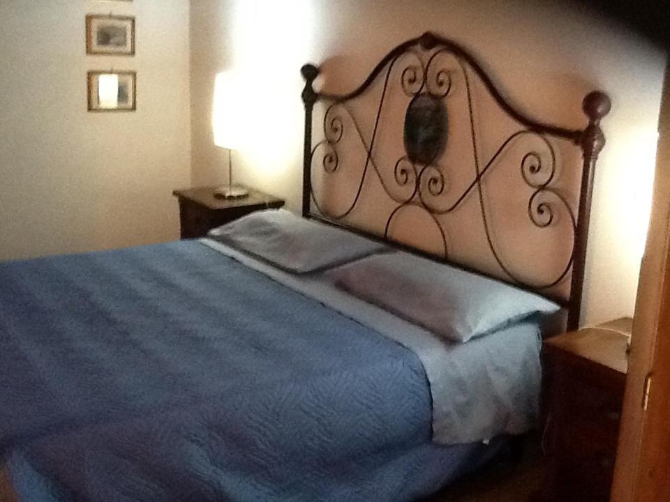 a bedroom with a large bed with a blue blanket at Rifugio di campagna in Vitorchiano