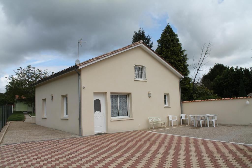 un edificio blanco con mesas y sillas delante en 18B Rue Winston Churchill, en Jonzac