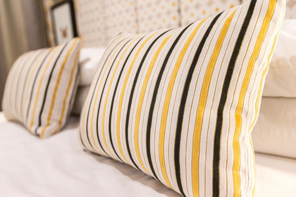 two striped pillows on a bed in a room at ASURE Destiny on Fitzherbert Motel in Palmerston North