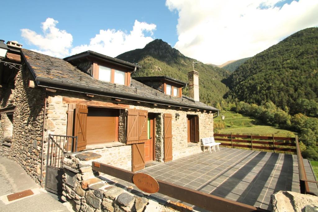 a stone house with a large deck in the mountains at Llorts, Casa Rustica, Ordino, Zona Vallnord in Llorts