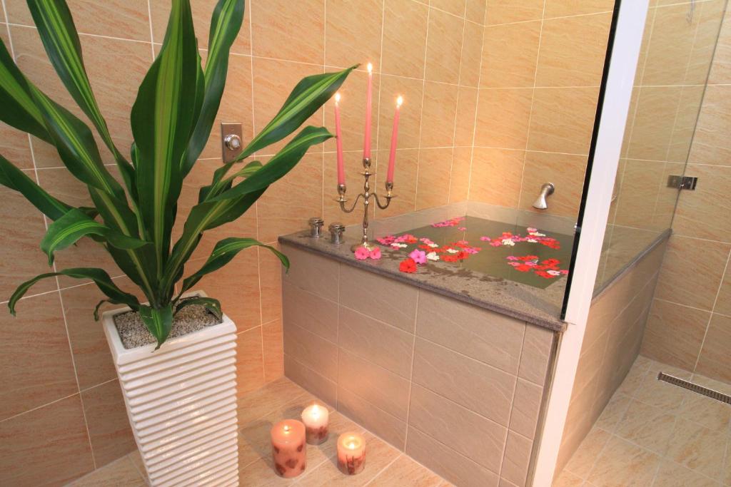 a bathroom with a plant in a tub with candles at Country Grange B&amp;B in Yuanshan