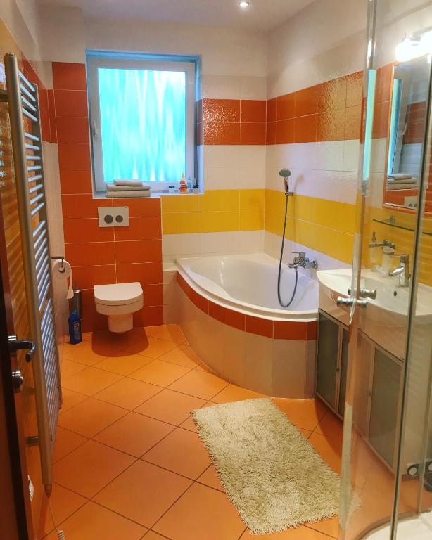 łazienka z wanną, toaletą i umywalką w obiekcie Apartmans Les w Zlinie