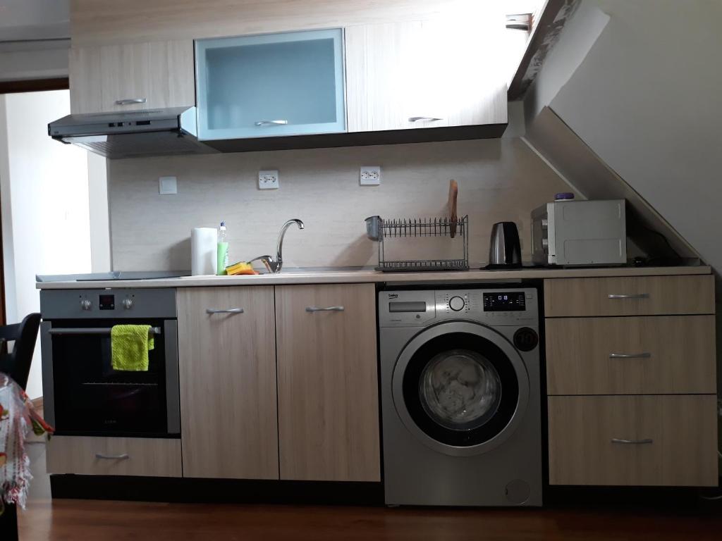 een keuken met een wasmachine en een wastafel bij Апартаменти Прометей in Boergas