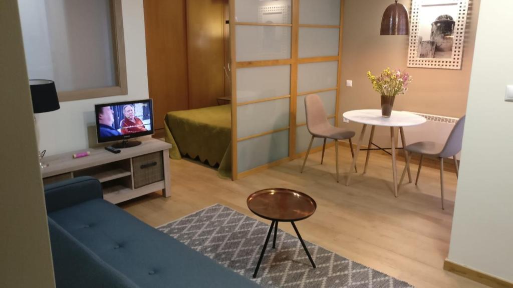 sala de estar con sofá azul y mesa en Coqueto apartamento centro VIGO con WIFI en Vigo