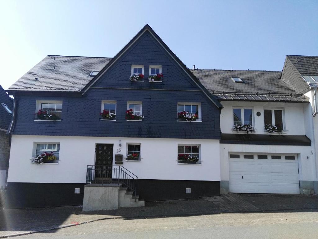 une maison blanche avec un toit noir dans l'établissement Schulinska Apartment, à Winterberg