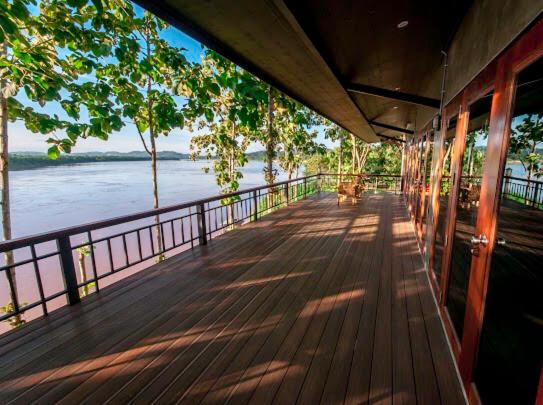 a wooden deck with a view of the water at Chiang Klong Riverside Resort in Chiang Khan