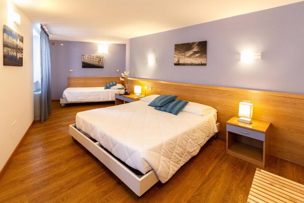 a bedroom with a large bed and two night stands at Hotel All'Arco in Trieste