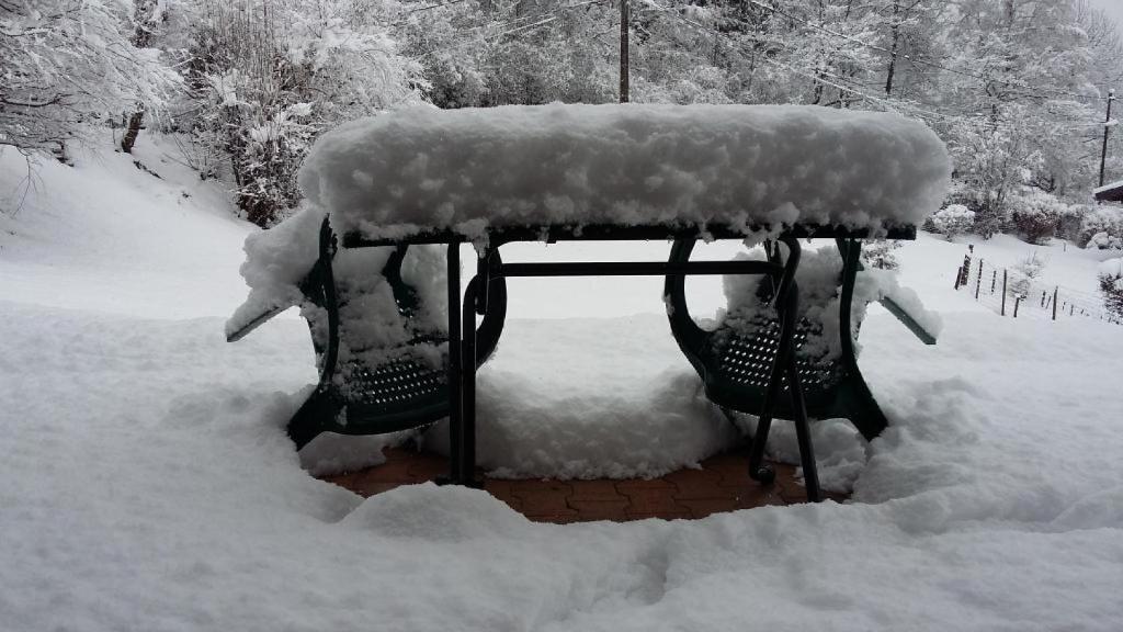 a bench covered in snow in a yard at Le Manège Ouest in Saint-Gervais-les-Bains