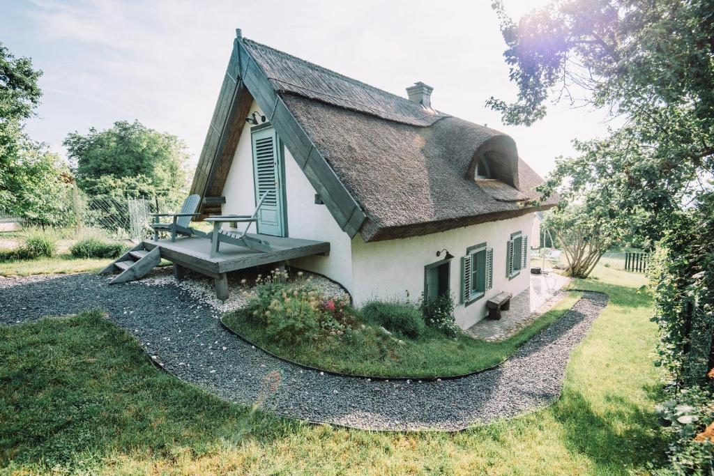 una pequeña casa con un banco a un lado en Noemi's Cottage, en Balatongyörök