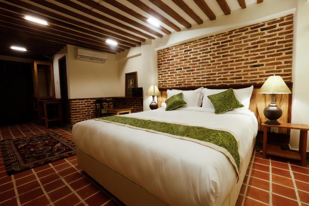 a bedroom with a large bed and a brick wall at Heranya Yala in Kathmandu