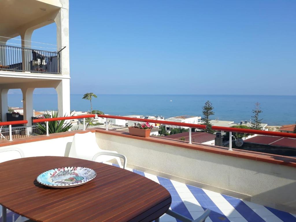 een tafel op een balkon met uitzicht op de oceaan bij Casa Azzurra in Alcamo Marina
