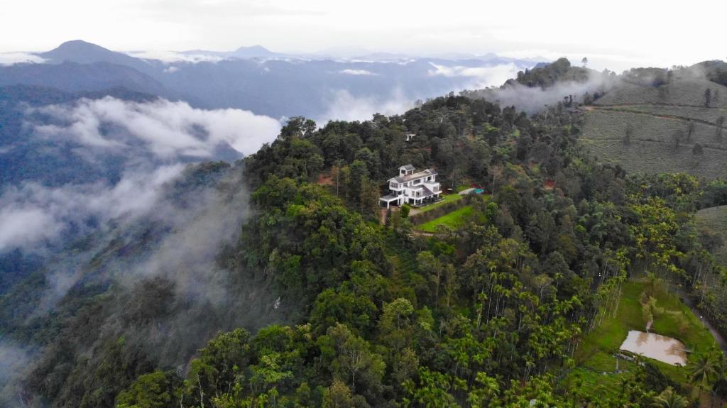a house on top of a hill in the forest at Chateau Woods in Kalpetta