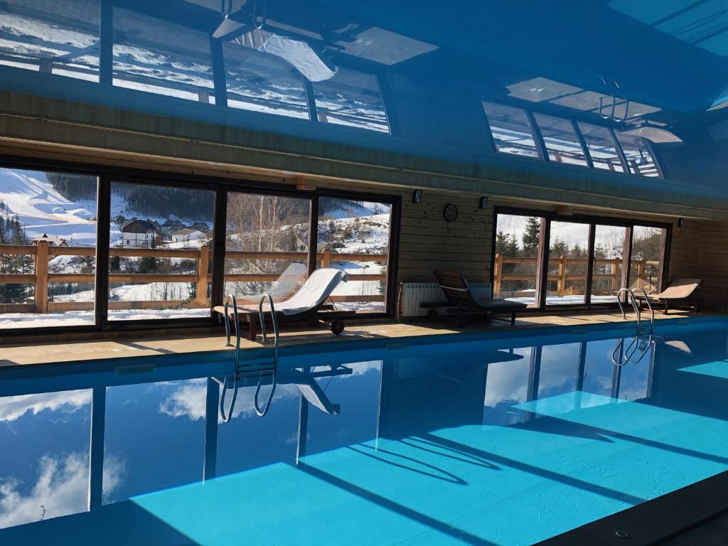 a swimming pool in a building with a view of the snow at Chalet du Mont in Bukovel
