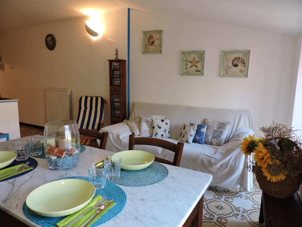 uma sala de estar com uma mesa com pratos em La Casa nel Borgo em Tellaro
