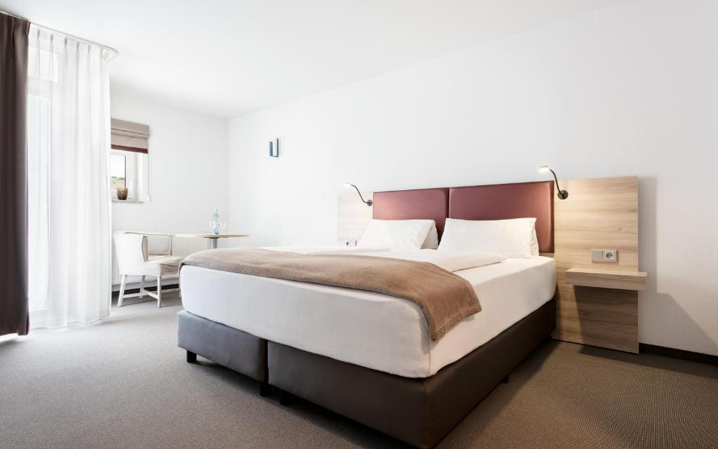 een slaapkamer met een groot bed en een tafel bij Donna Hotel Klosterhof in Neukirchen beim Heiligen Blut