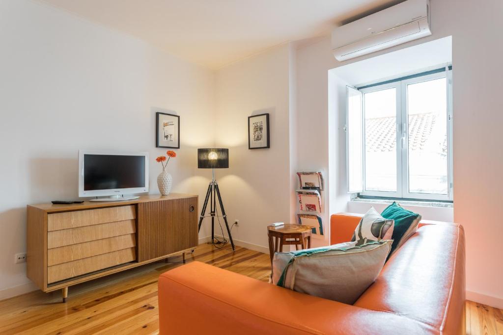 sala de estar con sofá y TV en Bairrus Lisbon Apartments - Rossio, en Lisboa