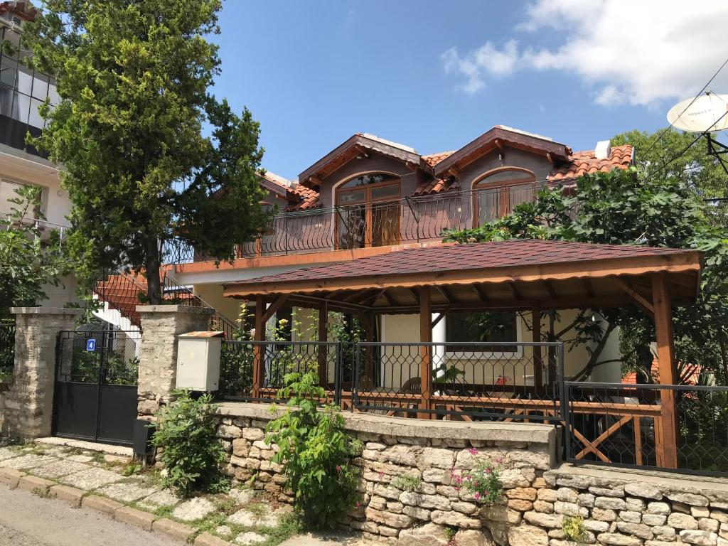 a house with a deck on top of a stone wall at Guest House Yoanna in Balchik