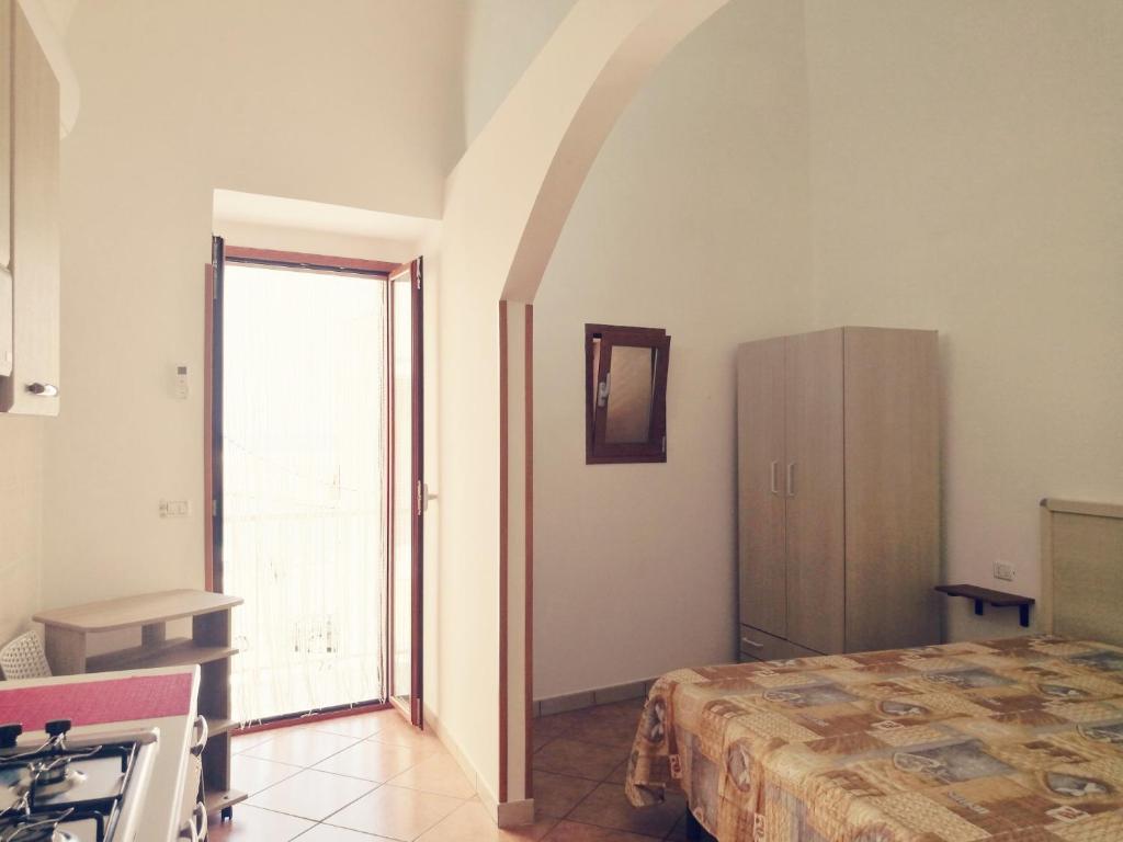 ヴィエステにあるAppartamento Tripoliのベッド、冷蔵庫、窓が備わる客室です。