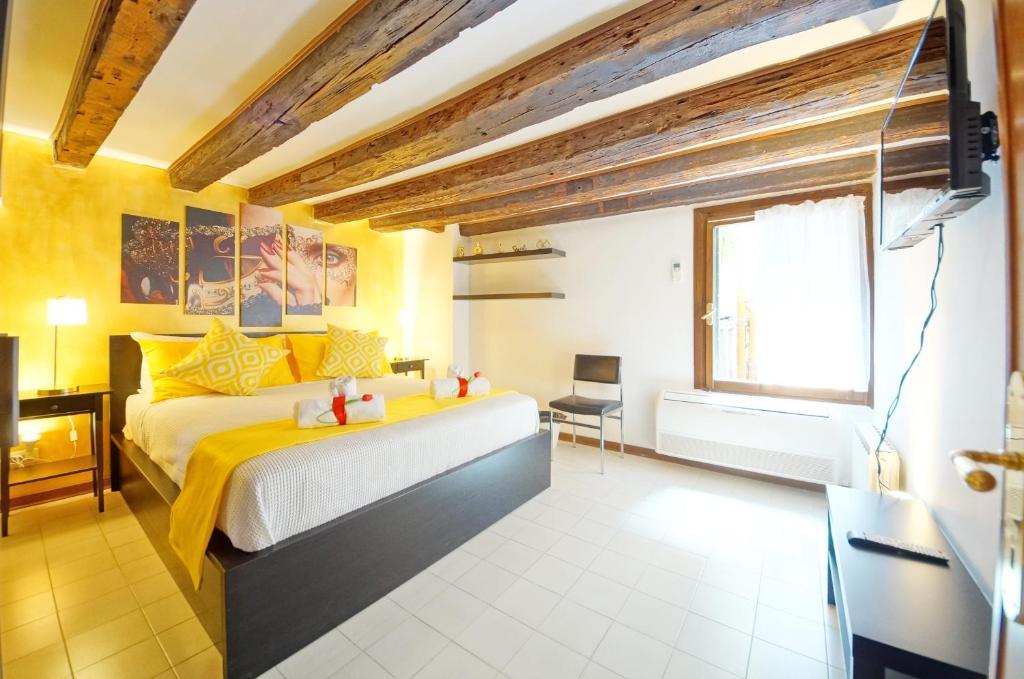 um quarto com uma cama grande e uma janela em Calle dei Fabbri San Marco Apartment em Veneza