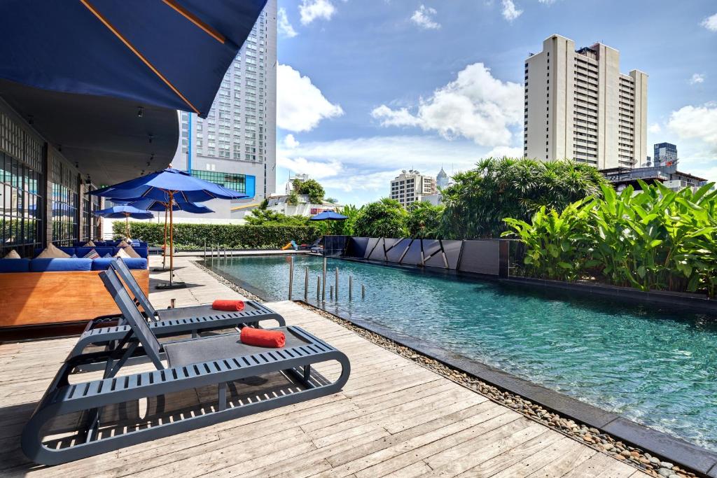 
a bench sitting on top of a pier next to a body of water at Fraser Suites Sukhumvit Bangkok - SHA Extra Plus in Bangkok
