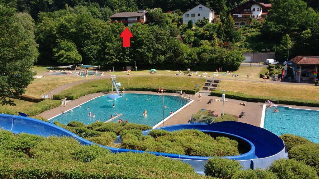 a large swimming pool with people in a park at Ferienwohnung Rhododendron - Natur pur Kinderparadies in Rotenburg an der Fulda