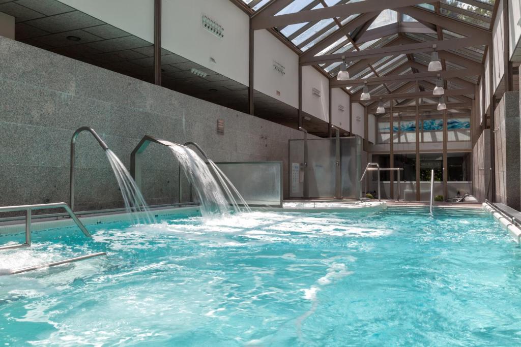 a large swimming pool with a water slide at Hotel Balneario de Compostela in Brion