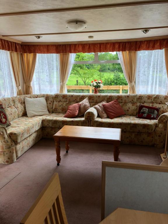 a living room with a couch and a table at 57 Glenfinart Caravan Park in Ardentinny