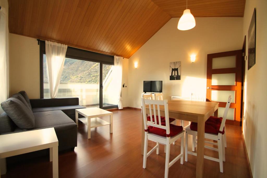 un soggiorno con un divano e un tavolo di Prat del Tirader, Atico en Encamp, Zona Grandvalira a Encamp