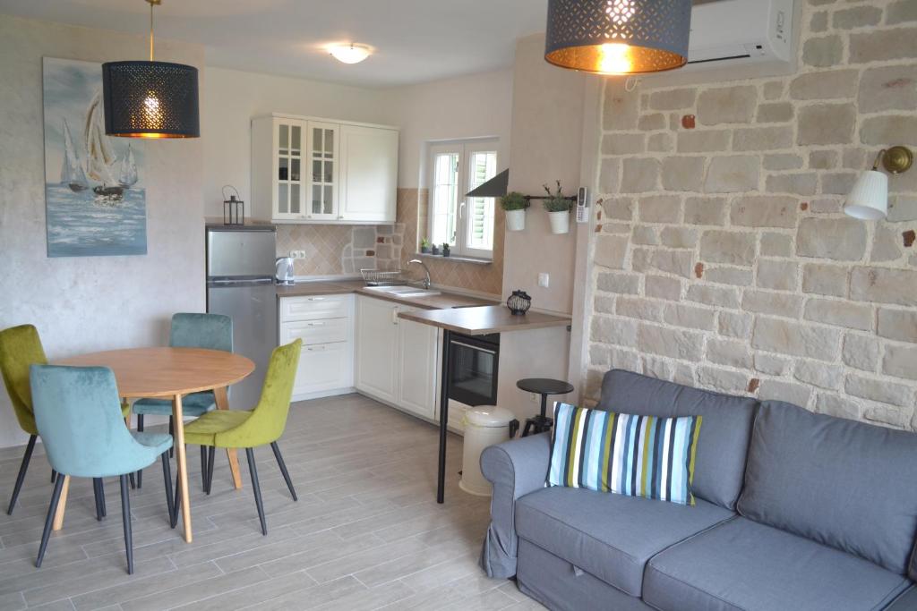 a kitchen and a living room with a couch and a table at Apartments Batistić in Supetarska Draga