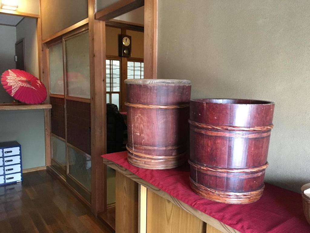 dos grandes barriles de madera sentados en un mostrador en una habitación en Fuji House en Takayama