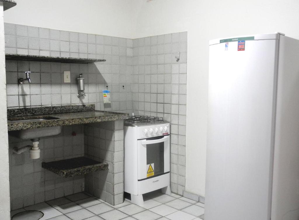a kitchen with a stove and a sink and a refrigerator at Praia Apart Hotel in Natal