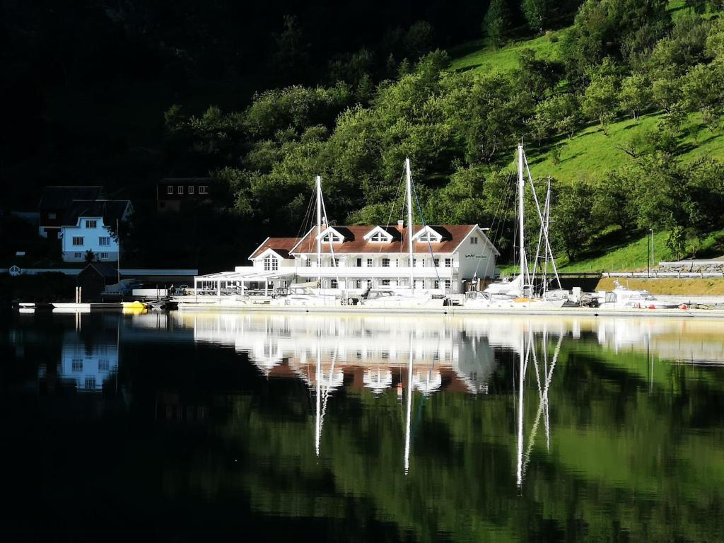 a large white house sitting on top of a body of water at Flåm Marina in Flåm