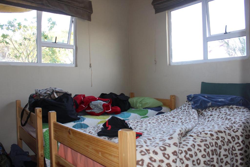 a bedroom with two beds with backpacks on them at The Wild Farm Backpackers in Wilderness