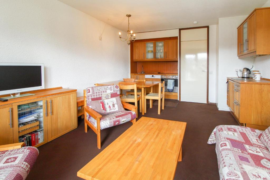 a living room with a tv and a dining room at Spacious Family Apartment, Immeuble Gemeaux in Flaine