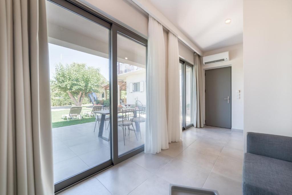 a large glass door in a living room with a table at Lemonia Accommodations in Lithakia