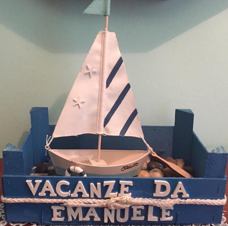 a cake with a sail boat in a blue box at Vacanze da Emanuele in Otranto
