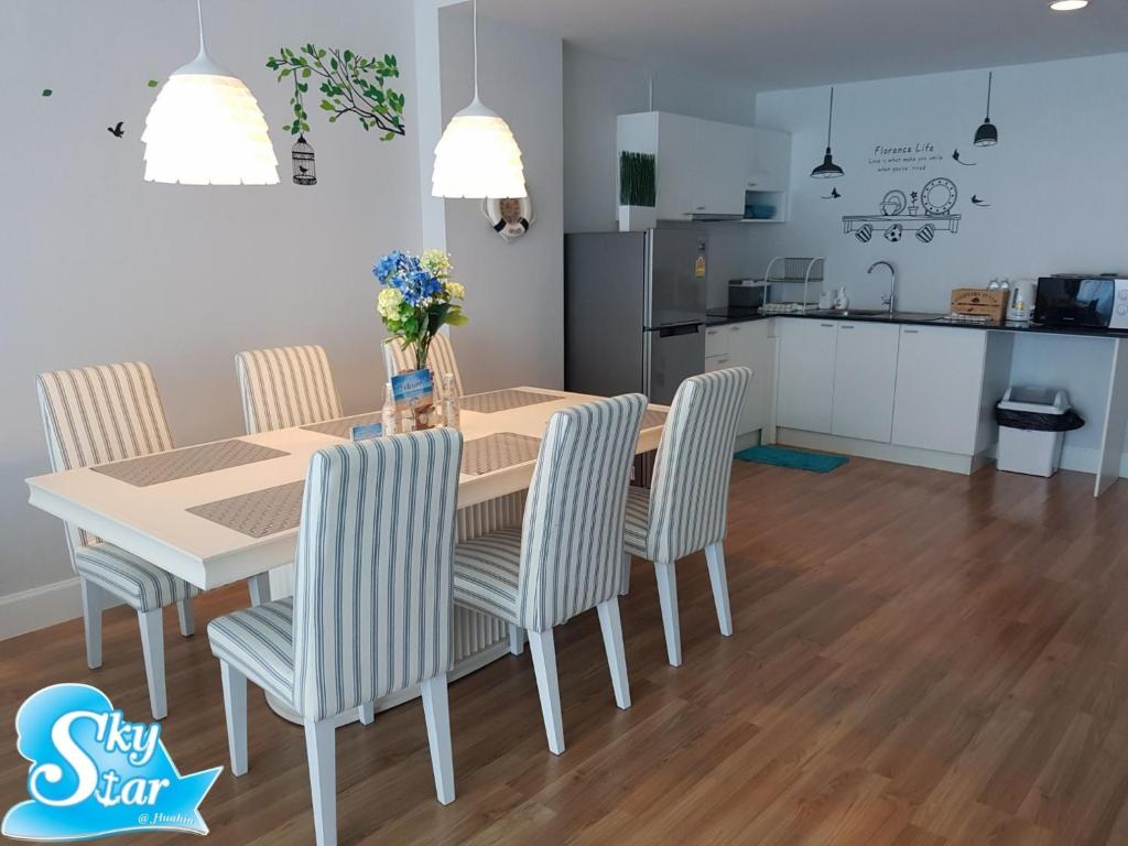 une table de salle à manger avec des chaises et une cuisine dans l'établissement My Resort Hua Hin by Skystar, à Hua Hin