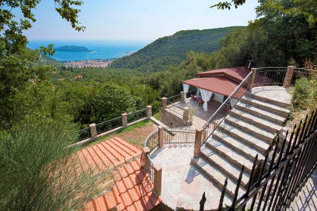 um conjunto de escadas que levam a uma casa com vista para o oceano em Holiday Home La Musica em Budva