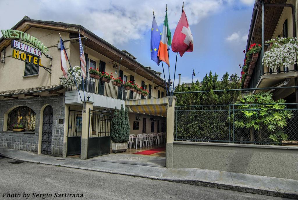 a building with flags on the side of it at Hotel Centro in Torre Pellice