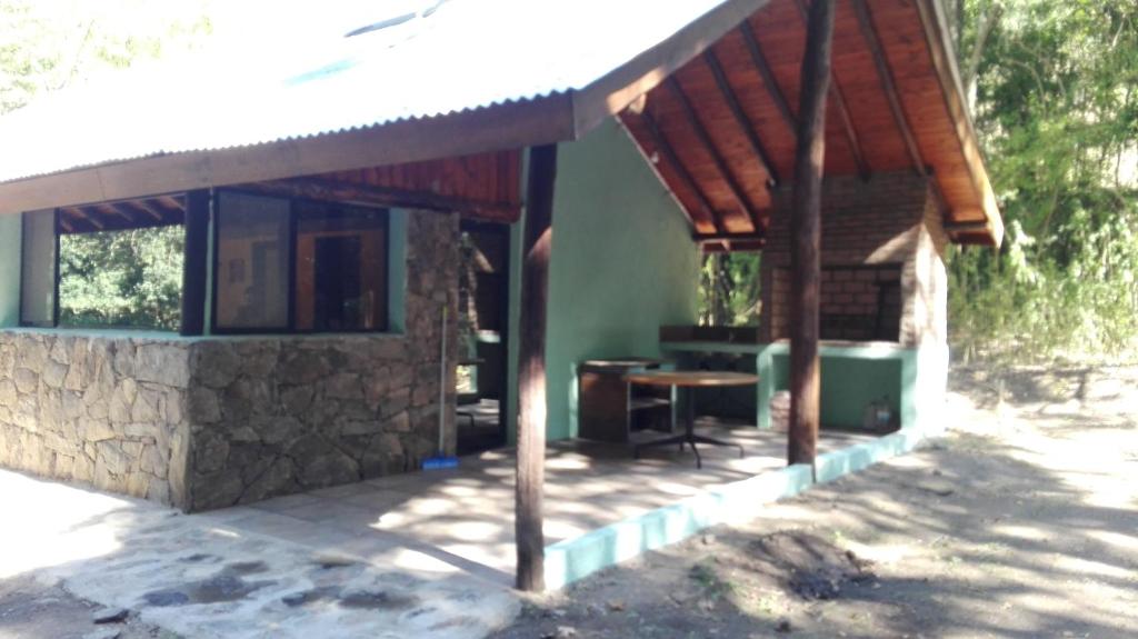 a small house with a wooden roof at Cabañas San Miguel in Villa Yacanto