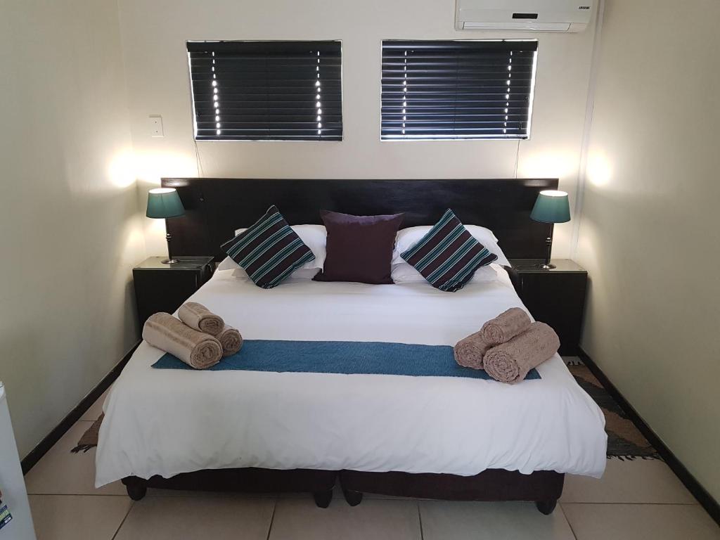 a bedroom with a large bed with towels on it at 360 Eastwoods Guesthouse in Pretoria