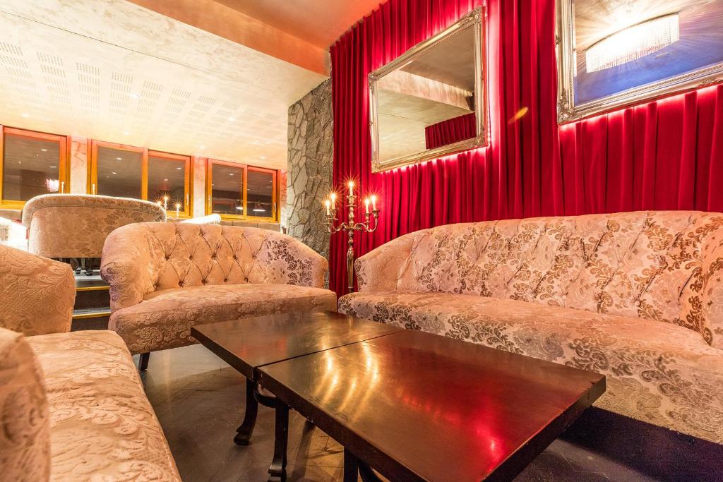 a living room with two couches and a table at Madame Vacances Hôtel & Spa Le Mottaret in Méribel