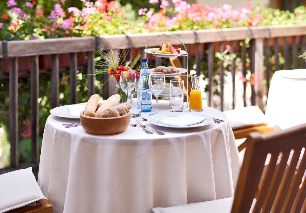 a table with a white table cloth and a plate of food at Schlosswirt Forst in Lagundo