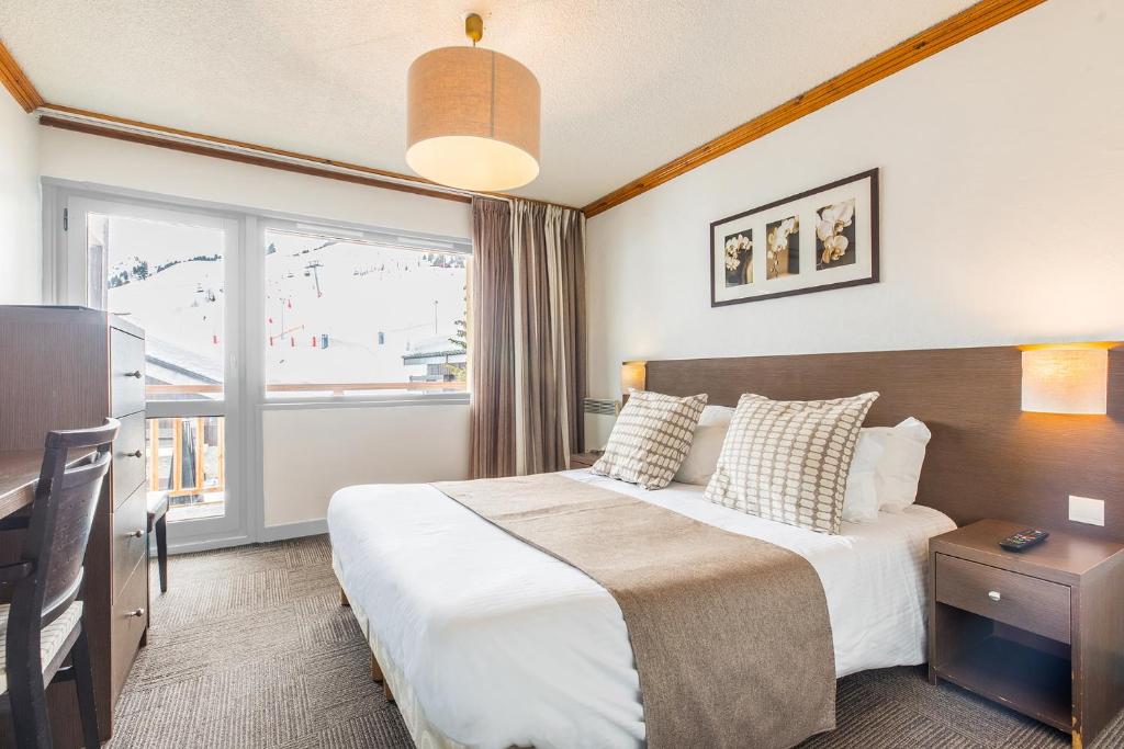 a hotel room with a bed and a window at Madame Vacances Hôtel & Spa Le Mottaret in Méribel