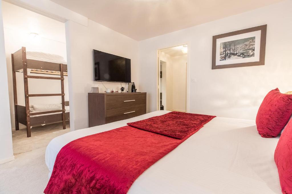 a bedroom with a bed with a red blanket on it at Madame Vacances Hôtel & Spa Le Mottaret in Méribel