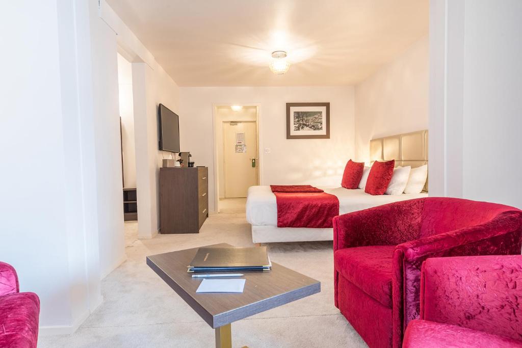 a hotel room with a bed and a couch and a table at Madame Vacances Hôtel & Spa Le Mottaret in Méribel