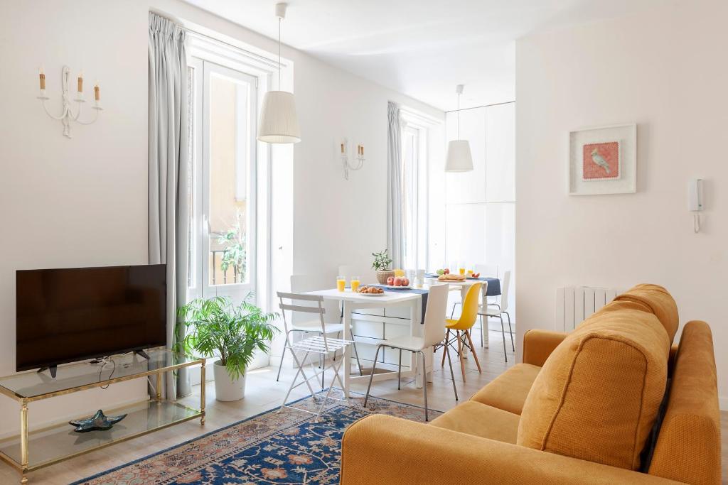 a living room with a couch and a tv and a table at Apartamento Smile Sol in Madrid