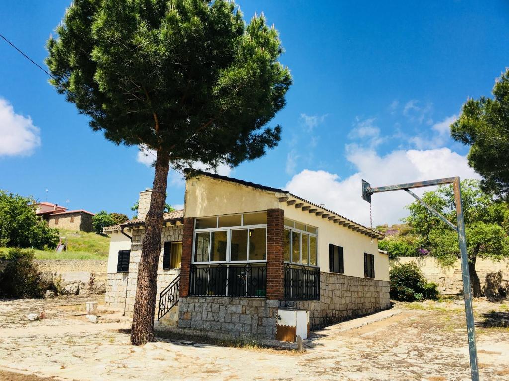 a house with a tree in front of it at Los Robles in Ávila