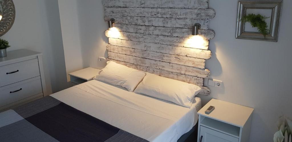 バレンシアにあるApartamento centro frente a Torres de Serranoのレンガの壁に照明付きのベッドが備わるベッドルーム1室が備わります。